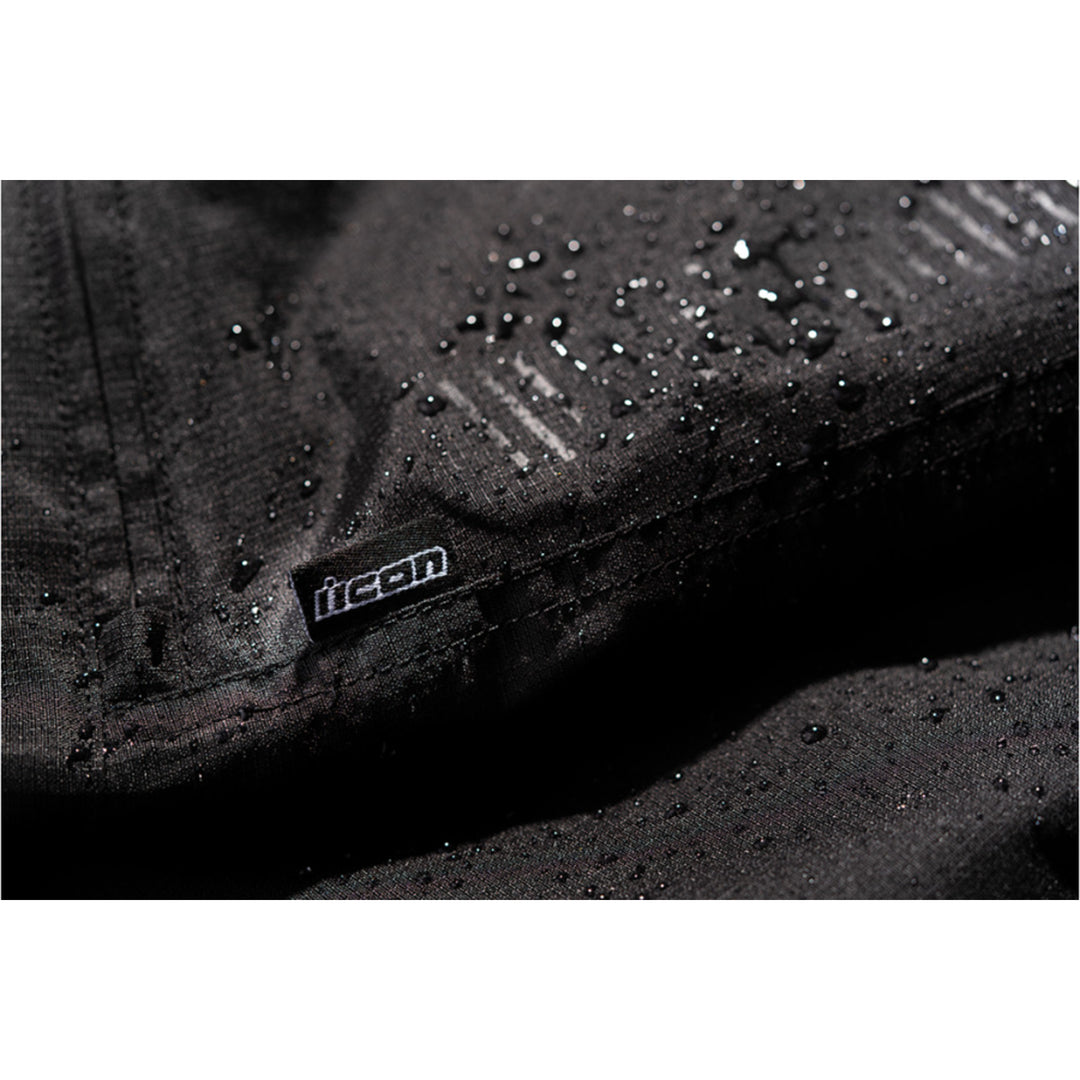 ICON PDX3 Overpant Black - Close-Up of Waterproof Material with Logo Tag Sewn into Seam