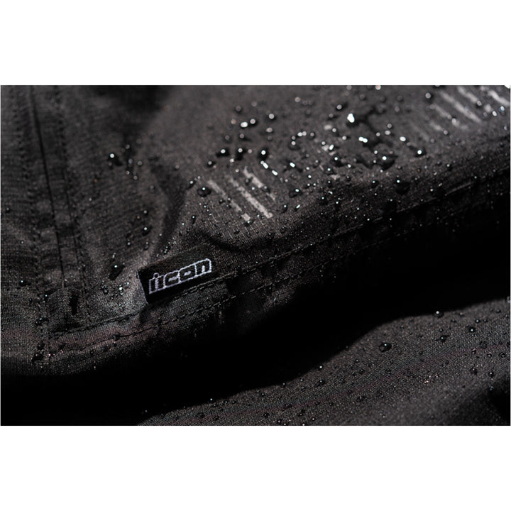 ICON PDX3 Overpant Black - Close-Up of Waterproof Material with Logo Tag Sewn into Seam