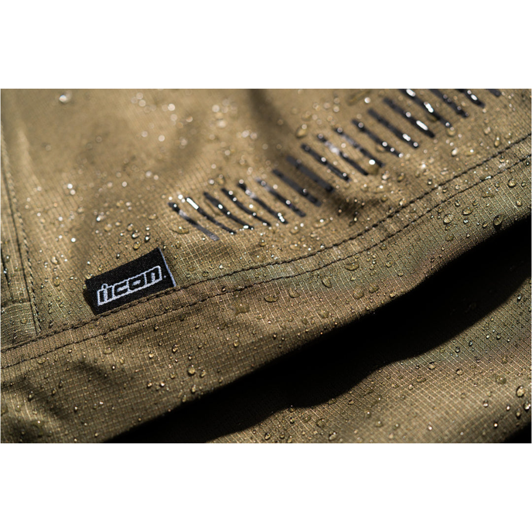 ICON PDX3 Overpant Olive - Close-Up of Waterproof Material with Logo Tag Sewn into Seam