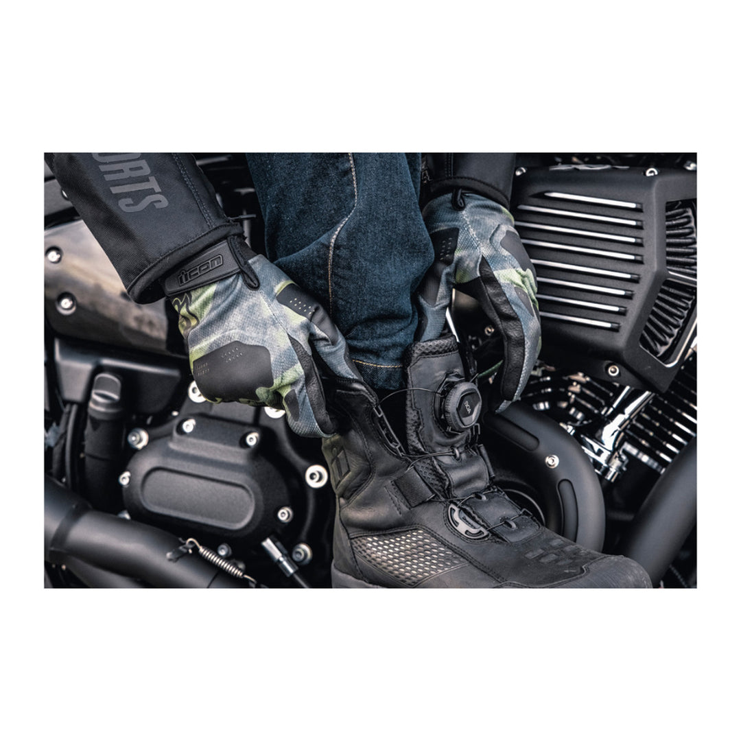 ICON Stormhawk Boots Black - Lifestyle Close-Up of Rider Reaching Down to Put On Boot