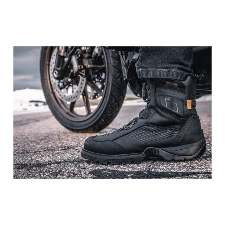 ICON Stormhawk Boots Black - Lifestyle Close-Up of Boot Set on Ground to Balance Motorcycle