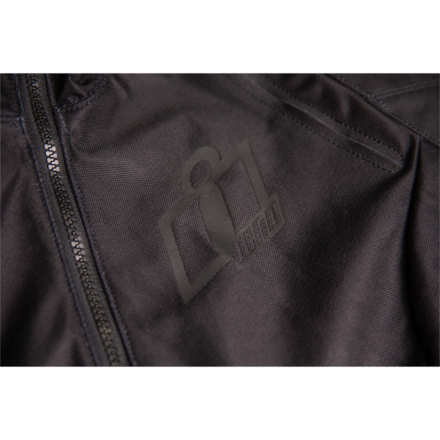 ICON Women's Airform Jacket Black - Close-Up of Logo Graphic on Chest