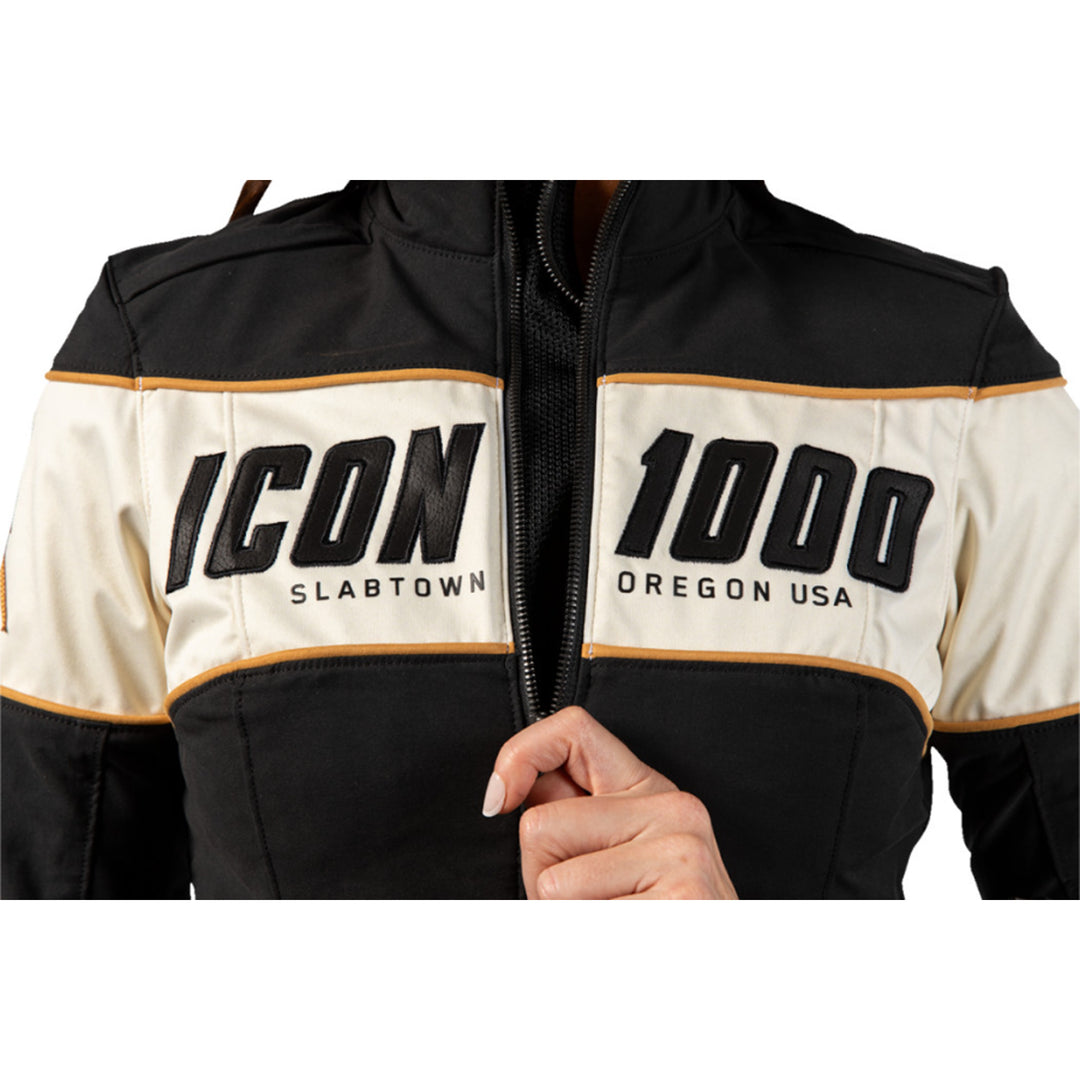 ICON Women's Hella 4 Jacket Black - Close-Up of Model Zipping Front Zipper