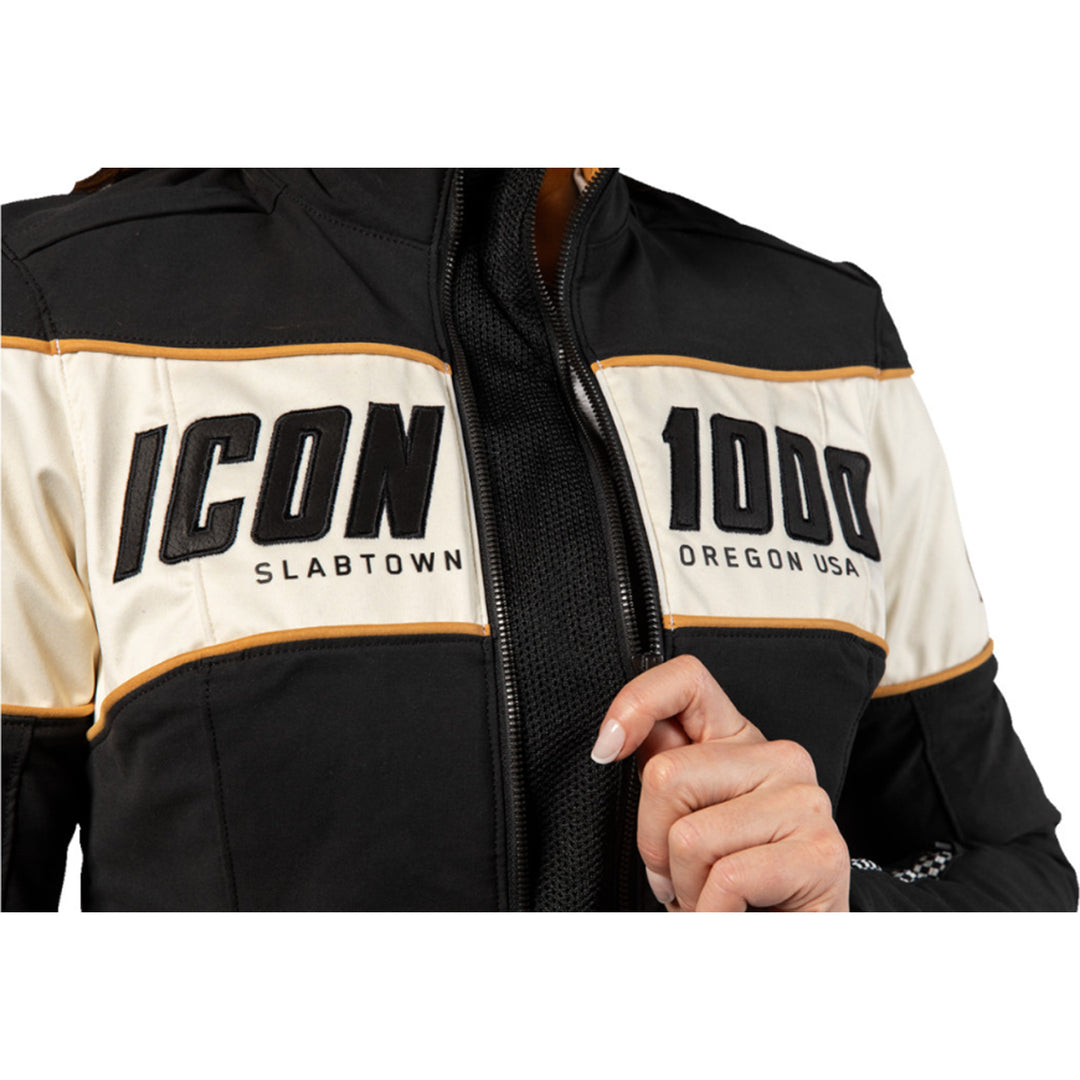 ICON Women's Hella 4 Jacket Black - Close-Up of Model Zipping Front Zipper with Expanded Mesh In-Between