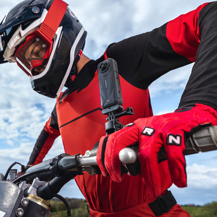 Insta360 X5 Motorcycle Bundle - Lifestyle Close-Up of Dirt Bike Rider Leaning Over Handlebars with X5 Camera Attached Next to Grip