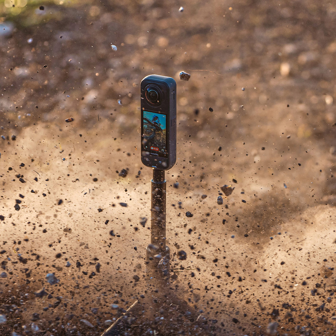 Insta360 X5 Motorcycle Bundle - Lifestyle Shot of X5 Camera on Tripod Getting Dusted by Passing Dirt Bike Rider