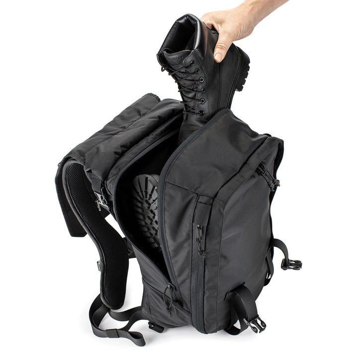 Kriega MAX28 Expandable Backpack - Top View with Model Placing Boots into Backpack