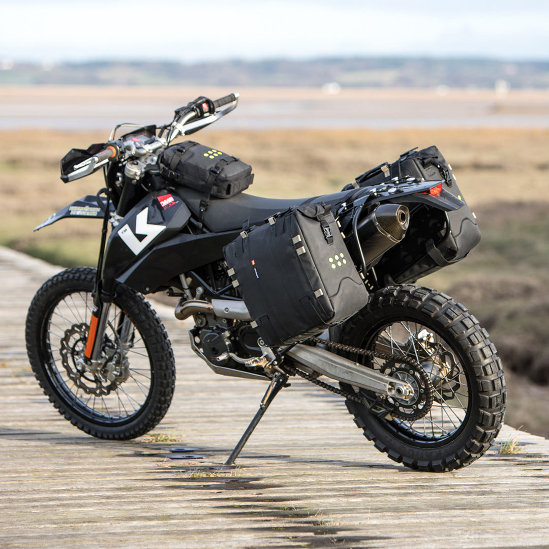 Kriega OS-32 Soft Pannier - Lifestyle of Pannier Installed on Both Sides of Parked Black Enduro Motorcycle