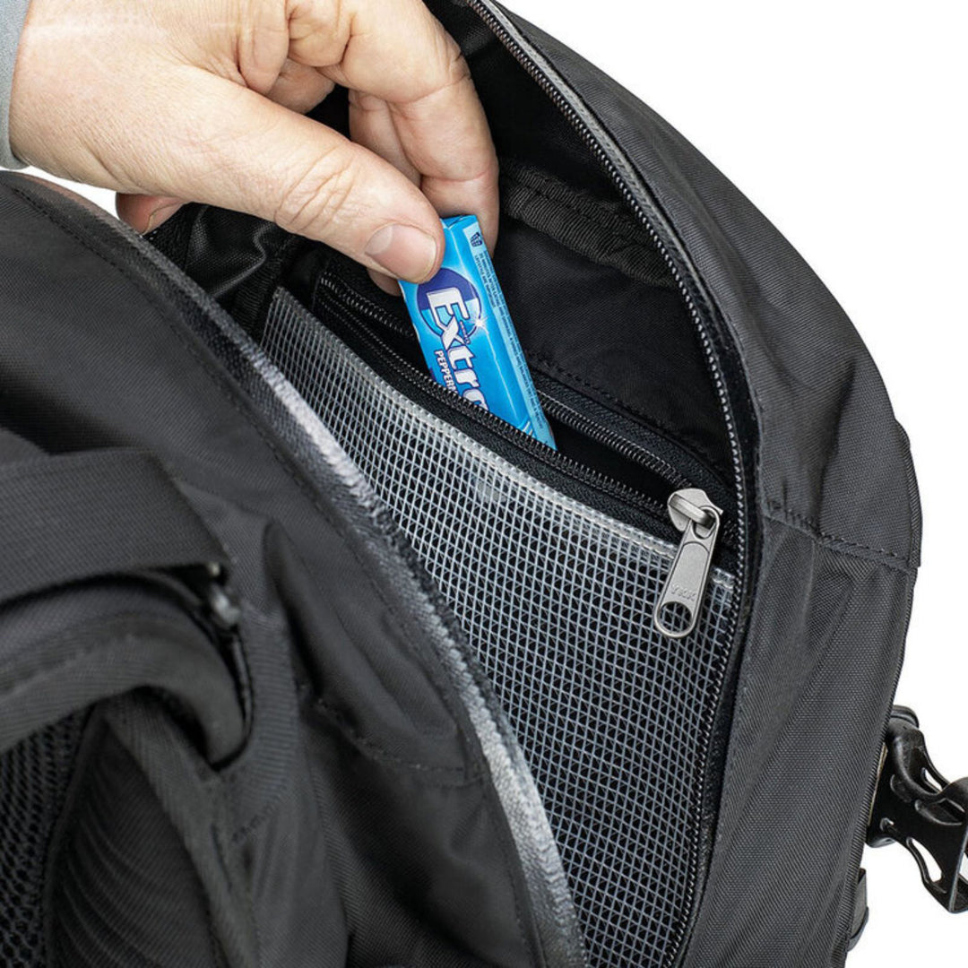 Kriega R20 Backpack - Close-Up Model Pulling Gum Out of Interior Zippered Pocket