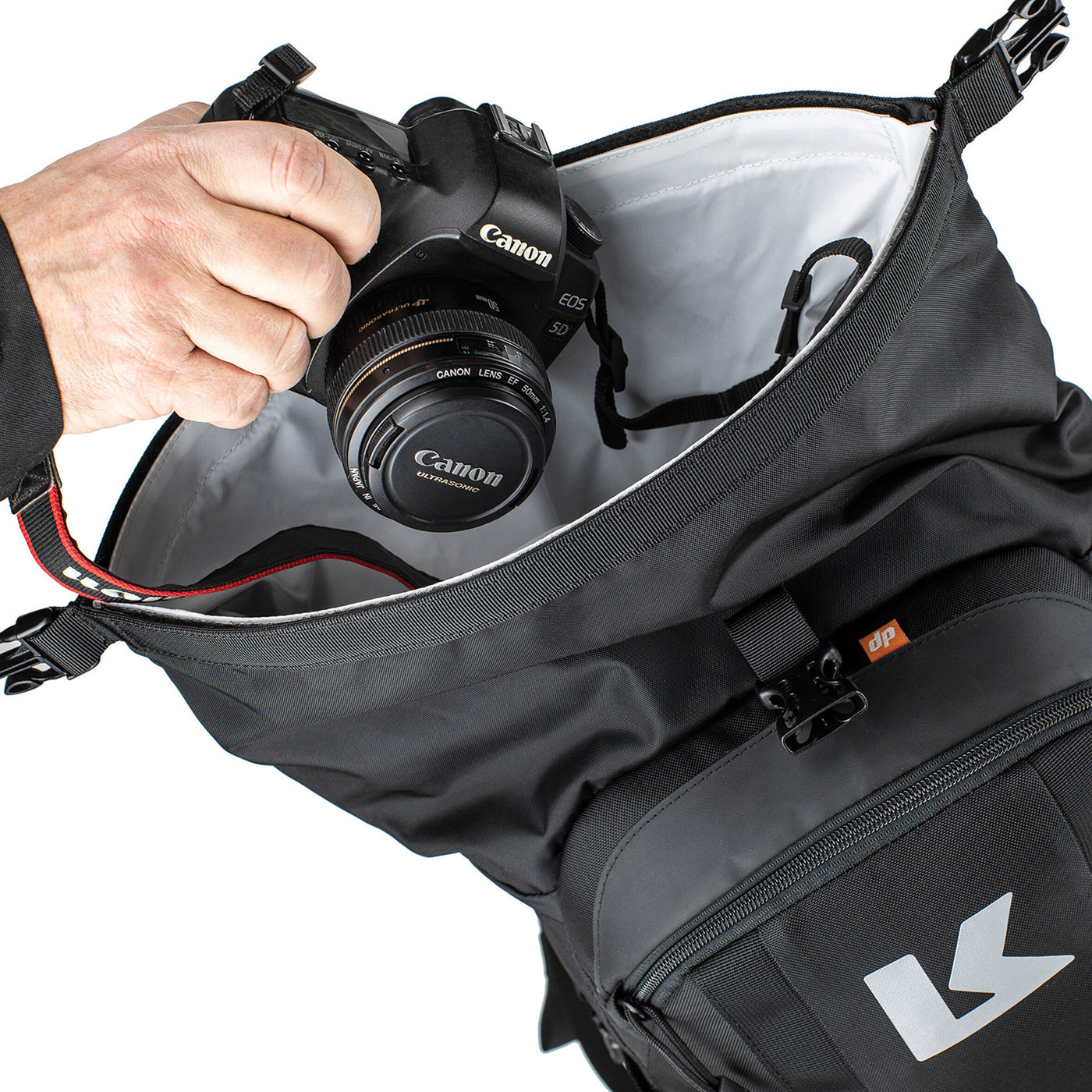 Kriega R22 Backpack - Close-Up of Model Placing Camera into Open Top Secton