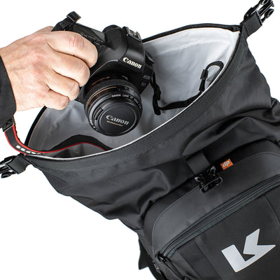 Kriega R22 Backpack - Close-Up of Model Placing Camera into Open Top Secton