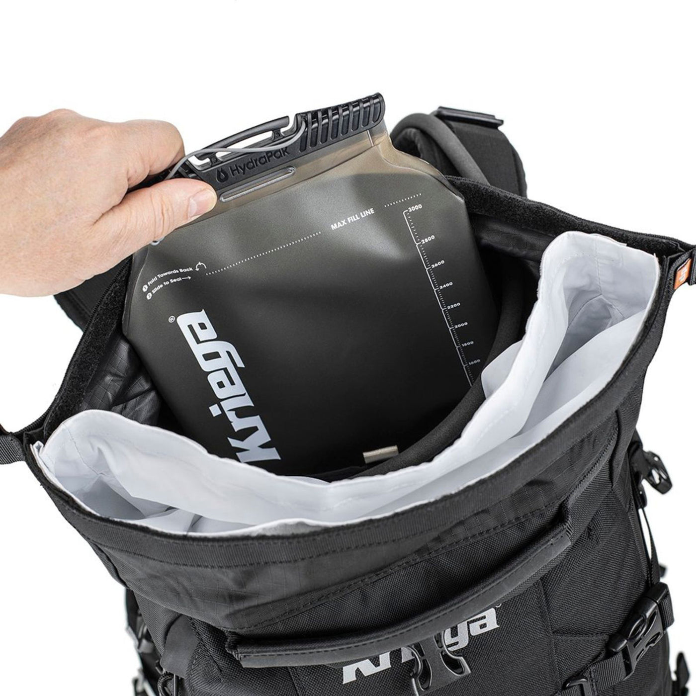 Kriega R25 V2 Backpack - Lifestyle Shot of hand placing water bladder in backpack