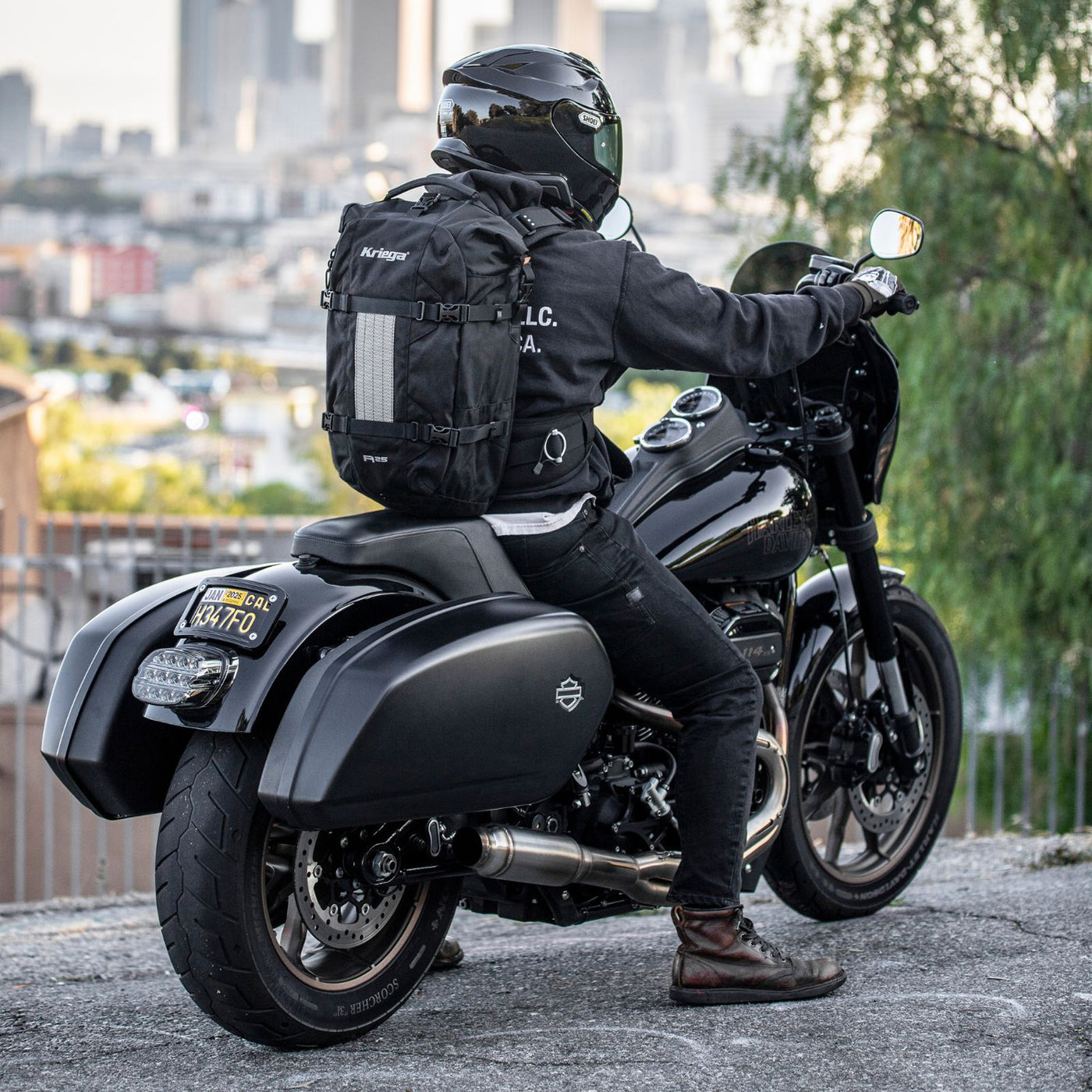 Kriega R25 V2 Backpack - Lifestyle Shot of Rider wearing backpack while sitting on motorcycle