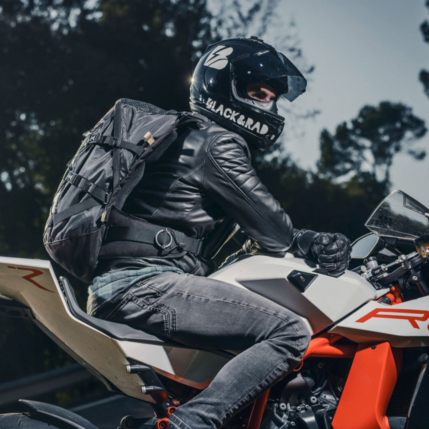 Kriega R35 Backpack - Lifestyle Shot of Rider Wearing Backpack while sitting on White Motorcycle