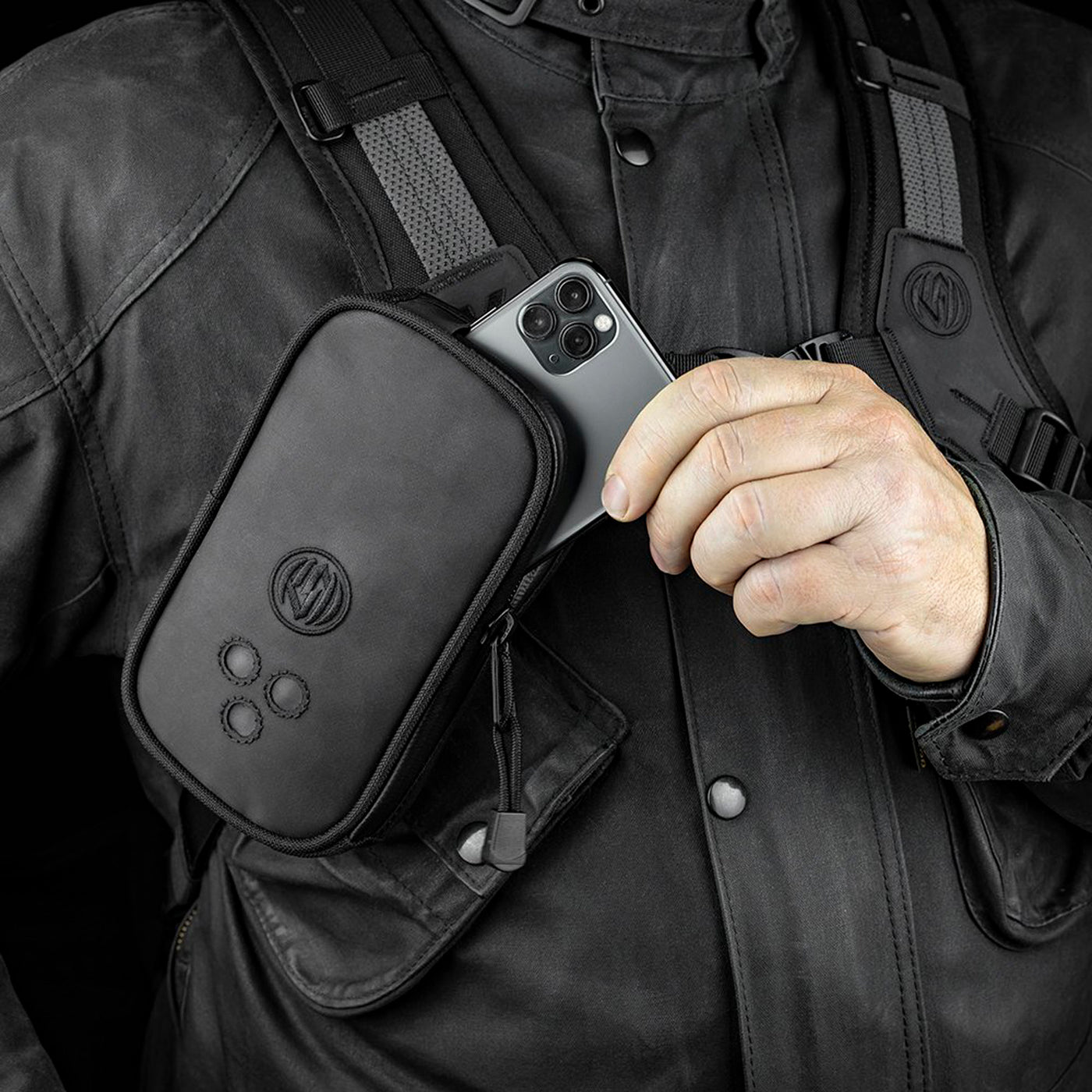 Kriega Roam Harness Pocket - Lifestyle Close-Up of Rider Placing Phone into Pocket Attached to Shoulder Strap