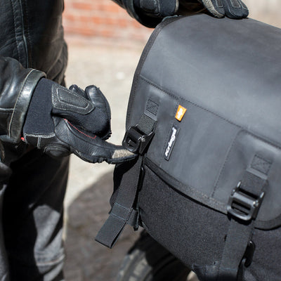 Kriega Saddlebags Duo-28 - Lifestyle of Rider adjusting lid Straps