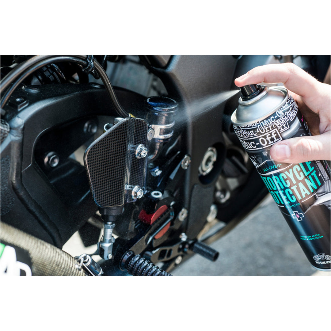 Muc-Off Motorcycle Protectant 500ml - Lifestyle Close-Up of Model Spraying Protectant on Foot Peg