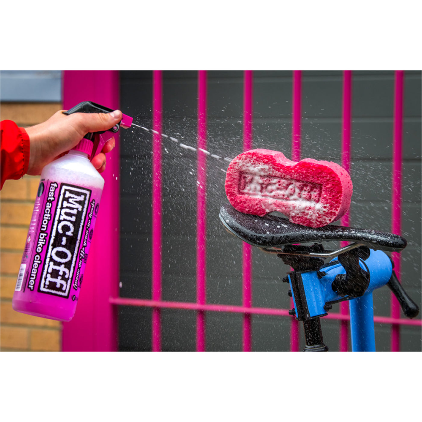 Muc-Off Punk Powder Concentrated Cleaner Refill - Lifestyle Close-Up of Model Spraying Cleaner into Sponge on Bicycle Seat