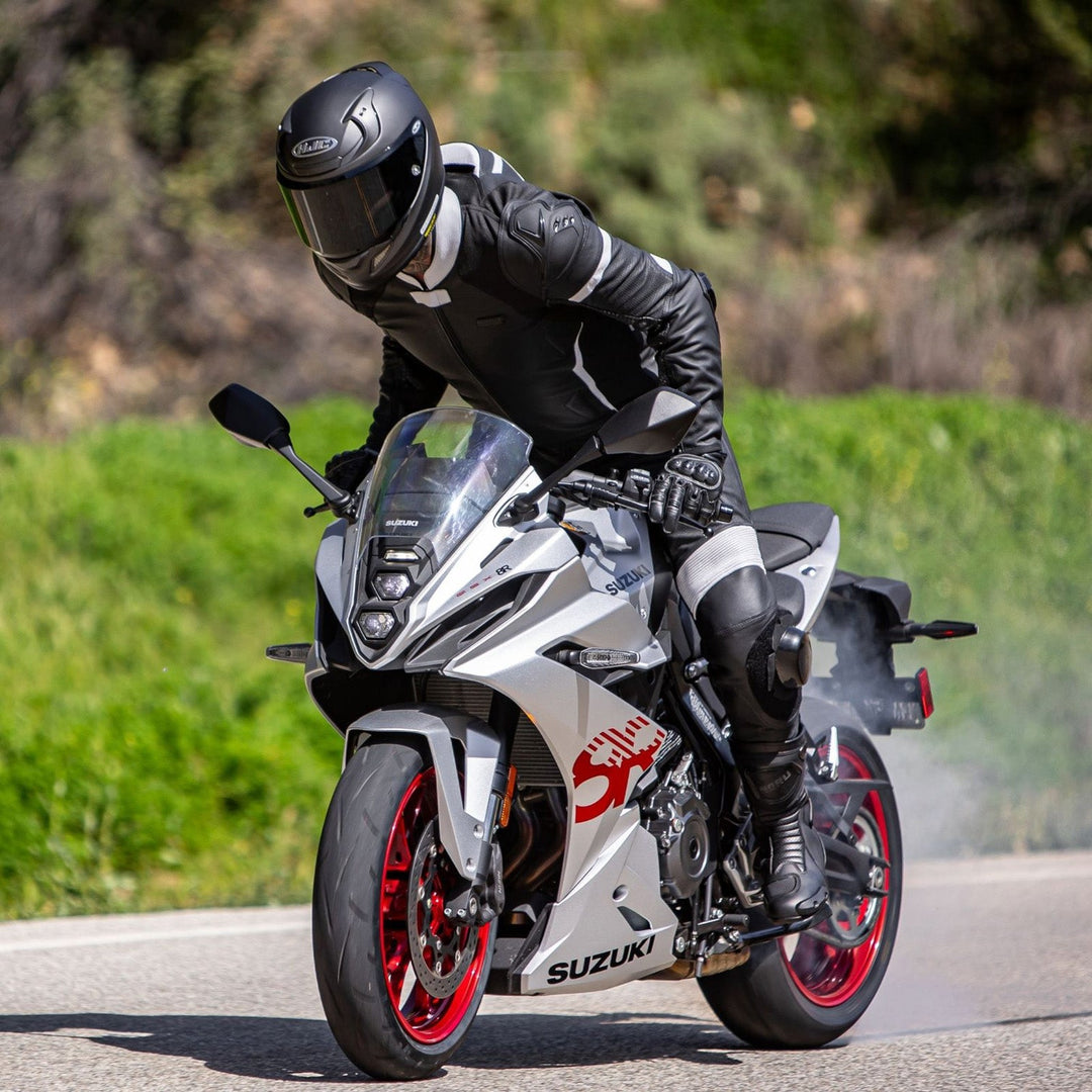 Noru Twenty-Eight 1-Piece Race Suit Black/White - Lifestyle of Rider Wearing Suit on Silver Sport Motorcycle