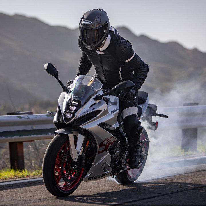 Noru Twenty-Eight 1-Piece Race Suit Black/White - Lifestyle of Rider Wearing Suit While Doing Burnout on Silver Sport Motorcycle