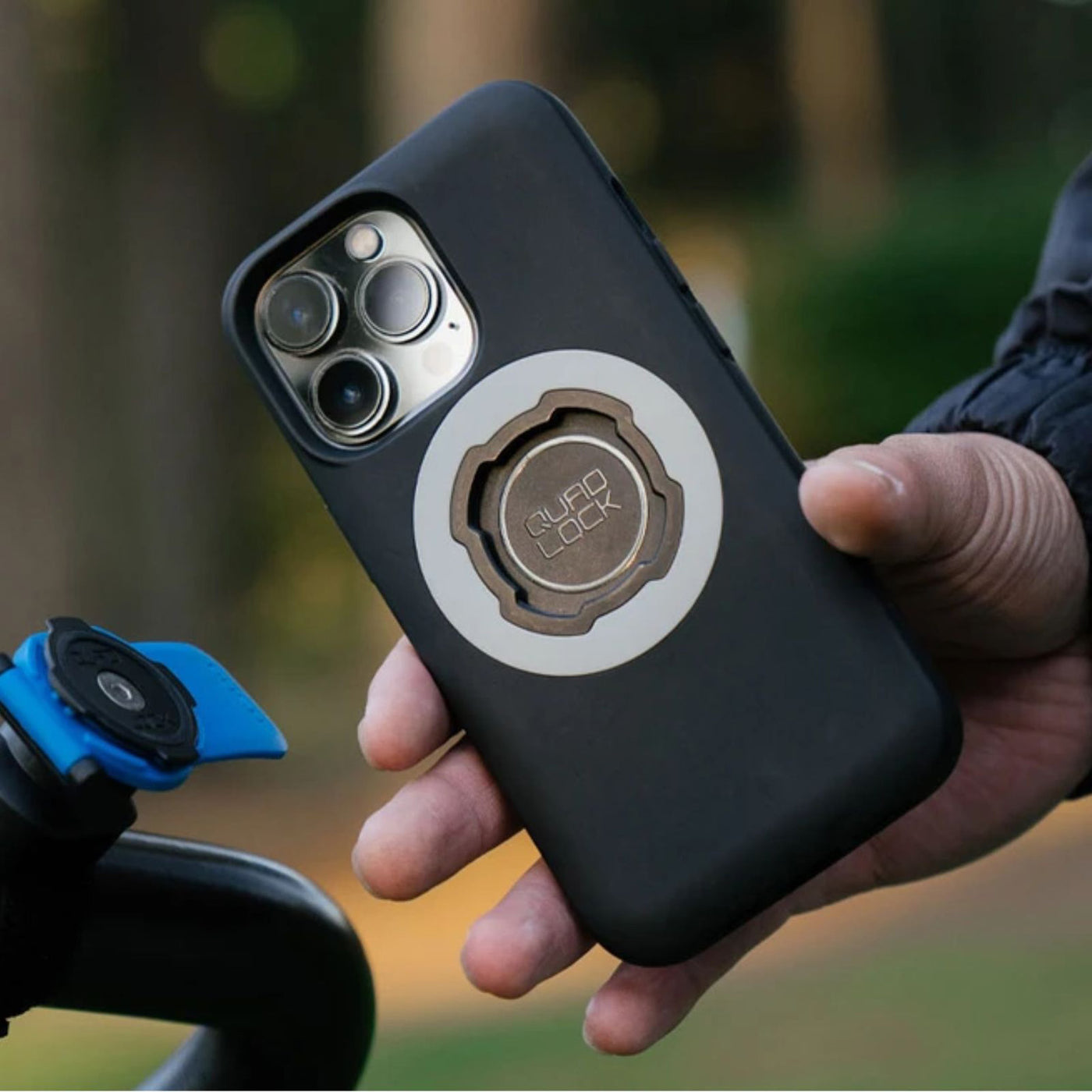 Quad Lock Phone Case - iPhone 16 Series MAG - Lifestyle Close-Up of Rider about to attach case to receiver head