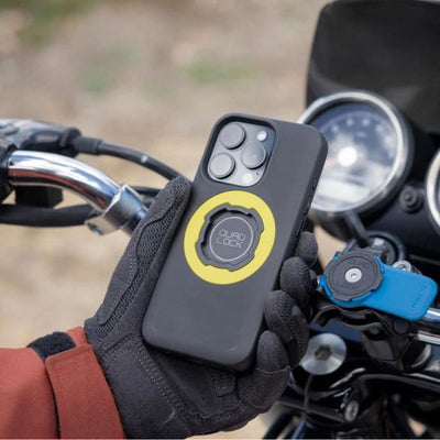 Quad Lock Phone Case - iPhone 16 Series MAG - Lifestyle shot of gloved hand holding phone case above motorcycle handlebar set-up