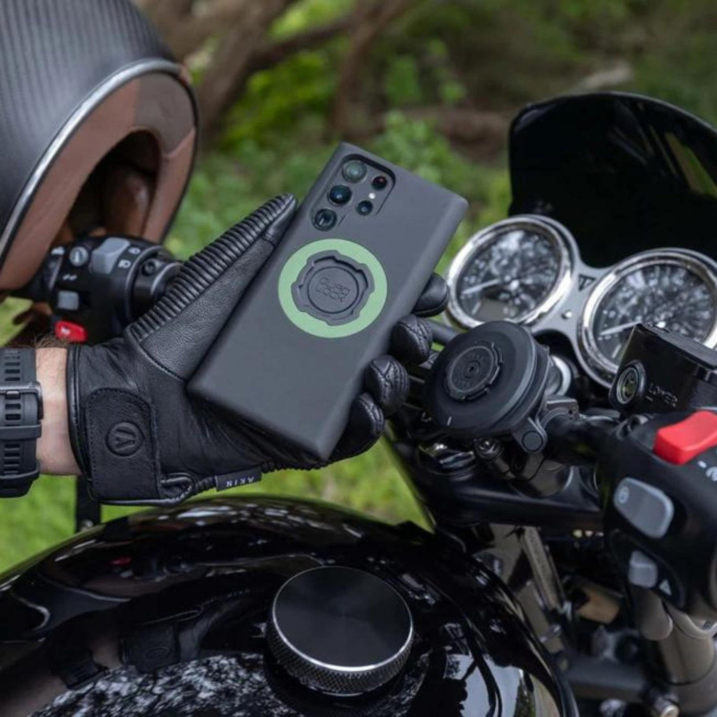 Quad Lock Phone Case - Samsung Galaxy S22 Series - Lifestyle Shot of gloved hand holding phone case over motorcycle handlebar set-up