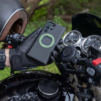 Quad Lock Phone Case - Samsung Galaxy S23 Series - Lifestyle Shot of gloved hand holding phone case over motorcycle handlebar set-up