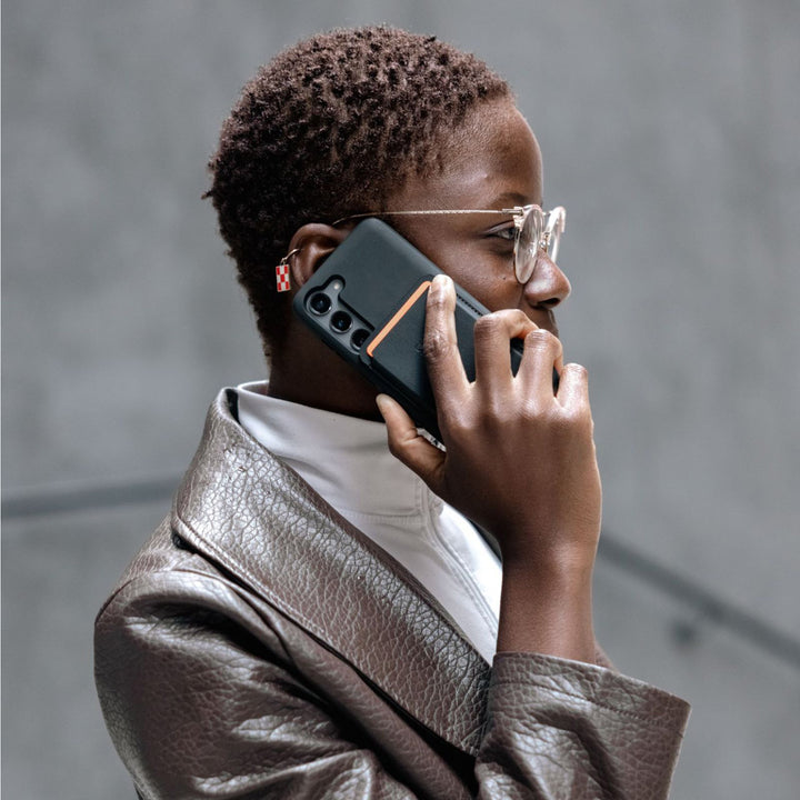 Quad Lock MAG Wallet - Lifestyle of User on Phone with Wallet Attached to Case