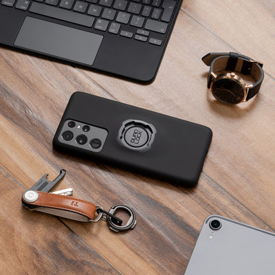 Quad Lock Phone Case - Samsung Galaxy S22 Series - Lifestyle Shot of phone case laying on desk next to watch, keyring, and laptop