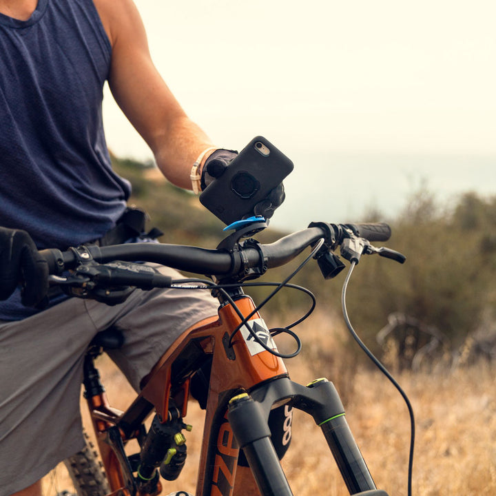 Quad Lock Out Front Mount - Lifestyle of Rider Locking Phone onto Mount