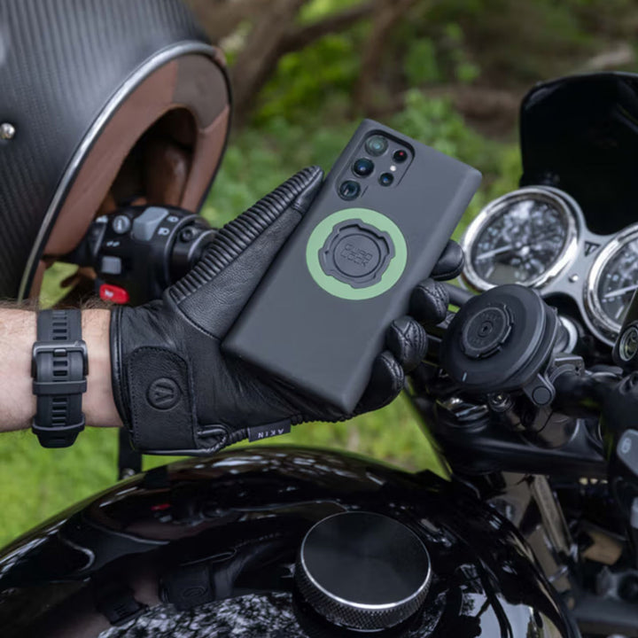 Quad Lock Phone Case - Samsung Galaxy S25 Series - Lifestyle Close-Up of Rider Attaching Phone with Case to Motorcycle Handlebar Mount