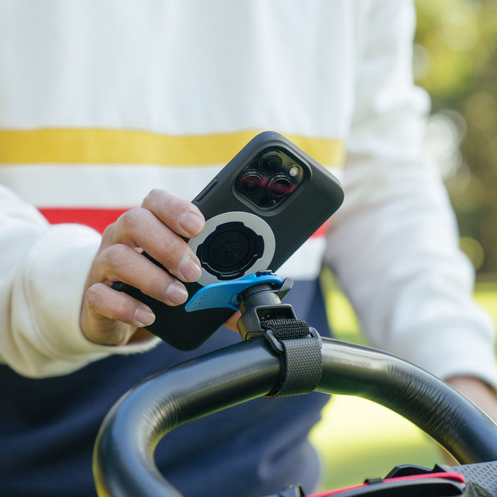 Quad Lock Quick Release Strap Mount - Lifestyle of Model Locking Phone onto Mount Strapped to Handle