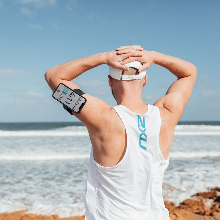 Quad Lock Sports Armband - Lifestyle of Jogger Facing Ocean with Phone on Armband
