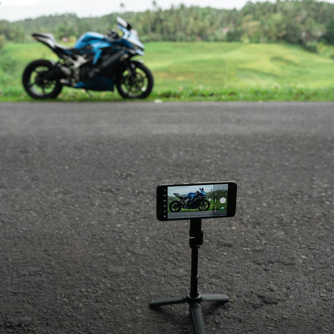 Quad Lock Tripod/Selfie Stick - Lifestyle of Phone on Extended Tripod Set to Take Picture of Motorcycle
