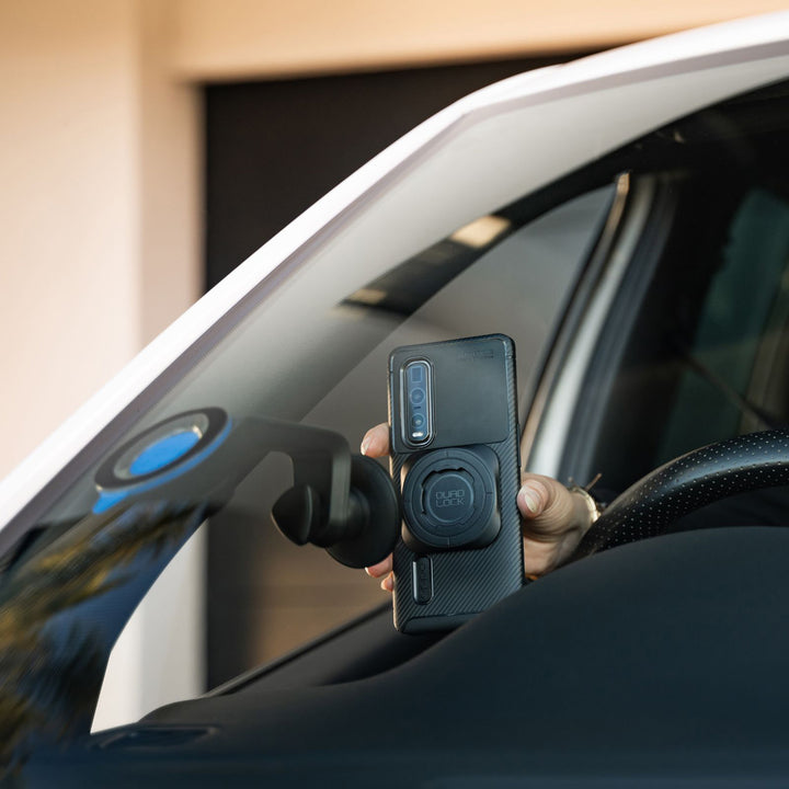 Quad Lock Universal Adaptor MAG - Lifestyle Close-up of Driver Locking Phone to Windshield Mount