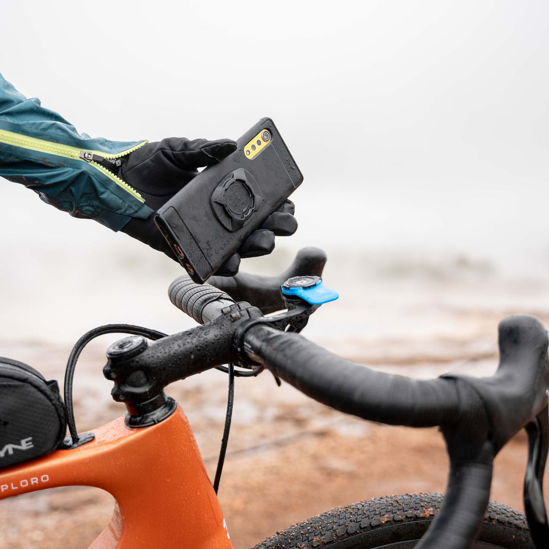 Quad Lock Universal Adaptor Original - Lifestyle of Cyclist Attaching Phone to Handlebar Mount