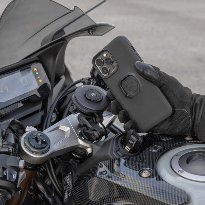 Quad Lock USB Weatherproof Wireless Charging Head - Lifestyle of Motorcycle Rider Lining Up Phone Case with Charging Head