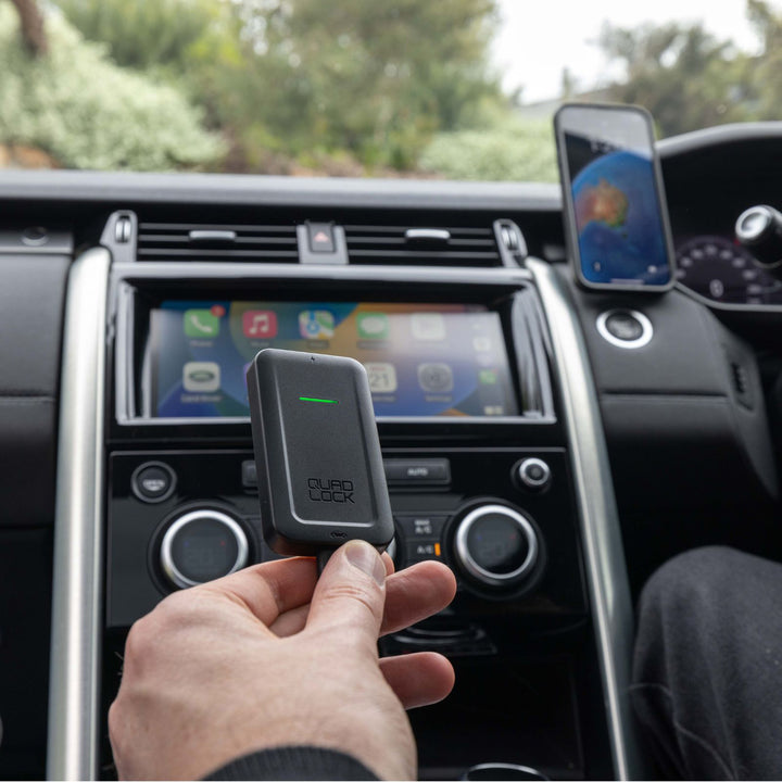 Quad Lock Wireless CarPlay Adaptor - Lifestyle of Driver Holding Up Adaptor over Center Console