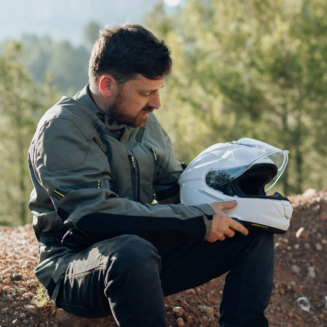 Shoei GT-Air 3 Solid Helmet White - Lifestyle of Rider Sitting on Dirt Mount and Holding Helmet