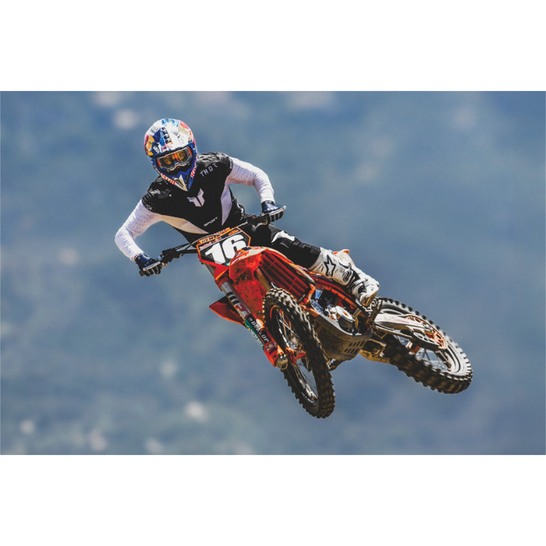 THOR SPORTMODE Strike Jersey Black - Lifestyle of Rider in Jersey Catching Air on Red Dirt Bike