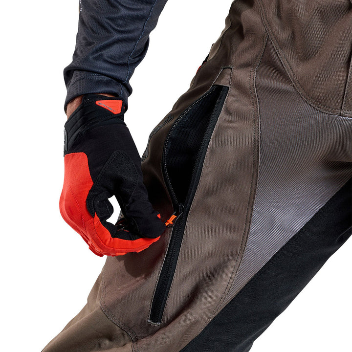 Troy Lee Designs Scout GP Solid Pants Tarmac - Close-Up of Model Opening Thigh Zippered Vent