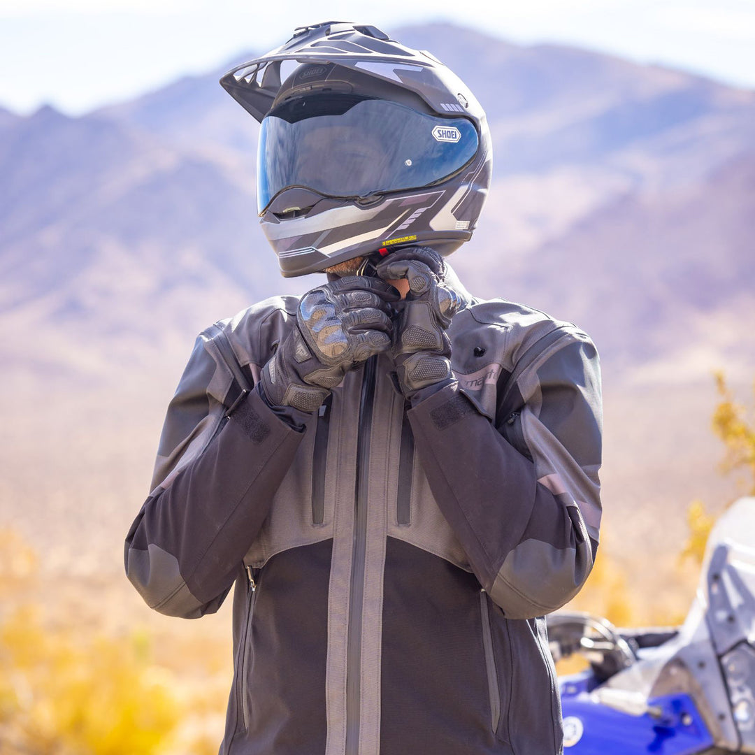 Tourmaster Adventure Lite Jacket Grey/Black - Lifestyle Shot of Rider Wearing Jacket while Adjusting Helmet Strap