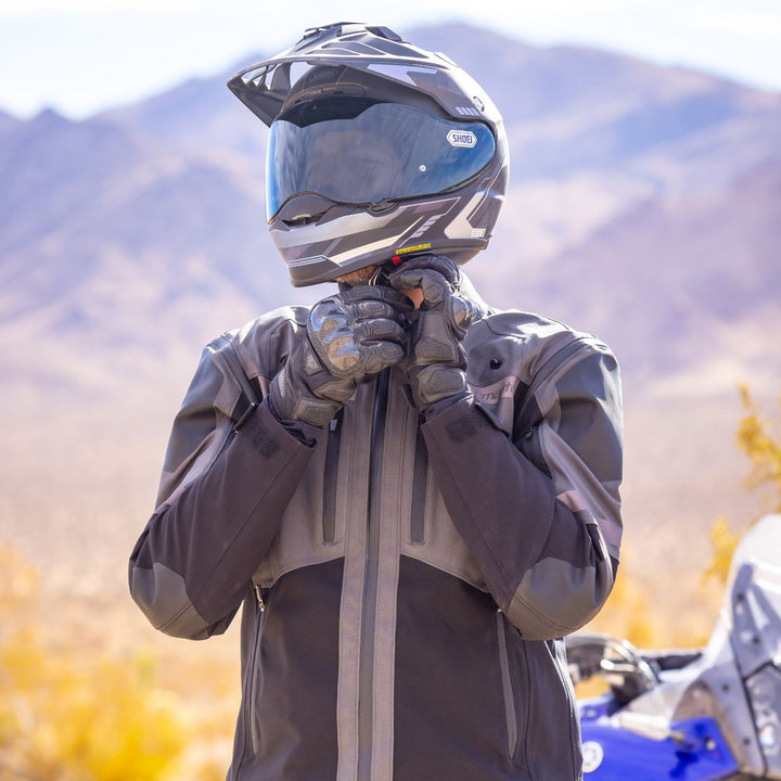 Tourmaster Adventure Lite Jacket Grey/Black - Lifestyle Shot of Rider Wearing Jacket while Adjusting Helmet Strap