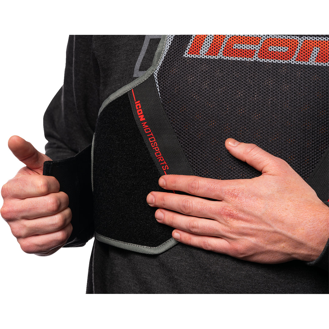ICON Field Armor Softcore™ Vest Megabolt Black - Close-Up of Model Adjusting Lower Chest Strap