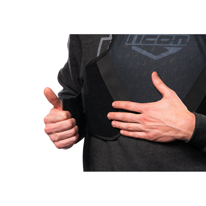 ICON Field Armor Softcore™ Vest Black - Close-Up of Model Adjusting Lower Chest Strap