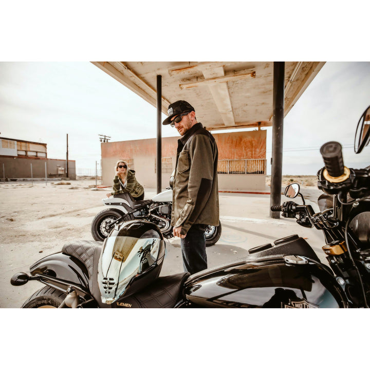 ICON Airflite™ Helmet FliteShield™ RST Lifestyle Shot of Helmet with RST Silver Fliteshield Resting on Black Motorcycle in Abandoned Gas Station