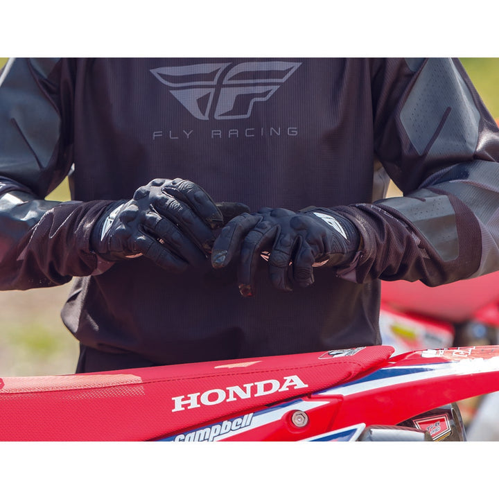 Fly Racing Patrol XC Lite Gloves Black/White - Lifestyle Close-Up of Rider Putting on Gloves Before Getting on Dirt Bike
