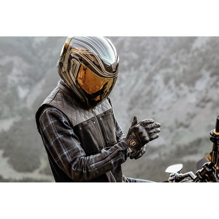ICON Chamonix Denim Vest Black - lifestyle of rider wearing vest while adjusting gloves